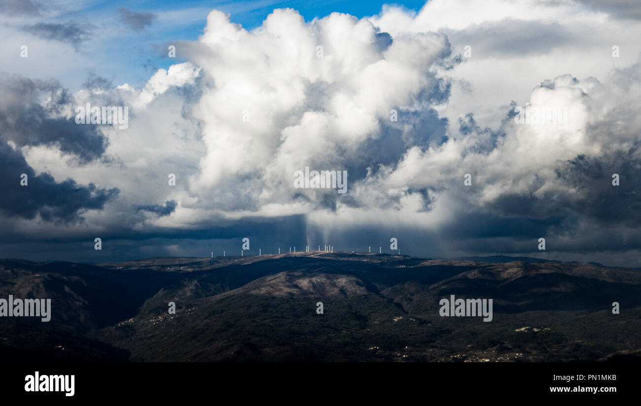 Eine seltsame Wolkenbildung über dem fernen Windkraftanlagen. Stockfoto