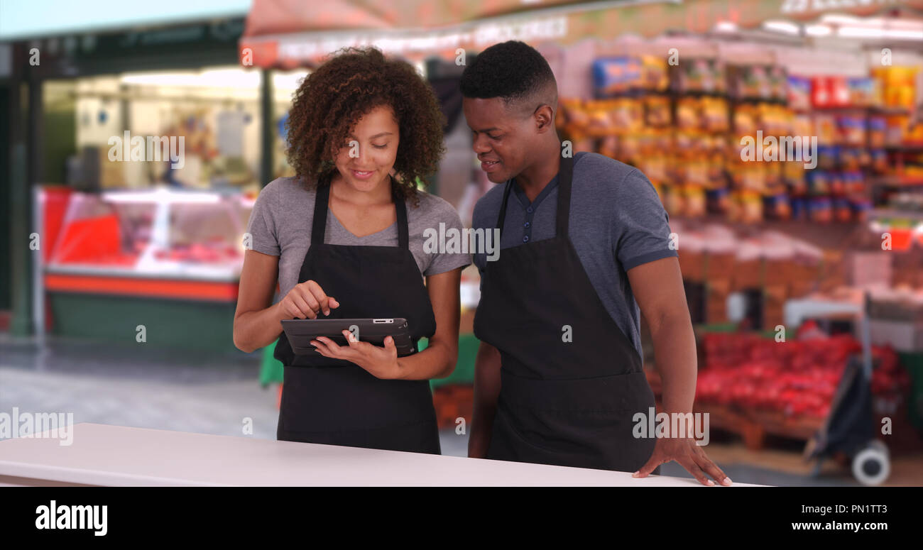 Schwarze männliche und weibliche Kellner mit digitalen Tablet an der London Street Market Stockfoto