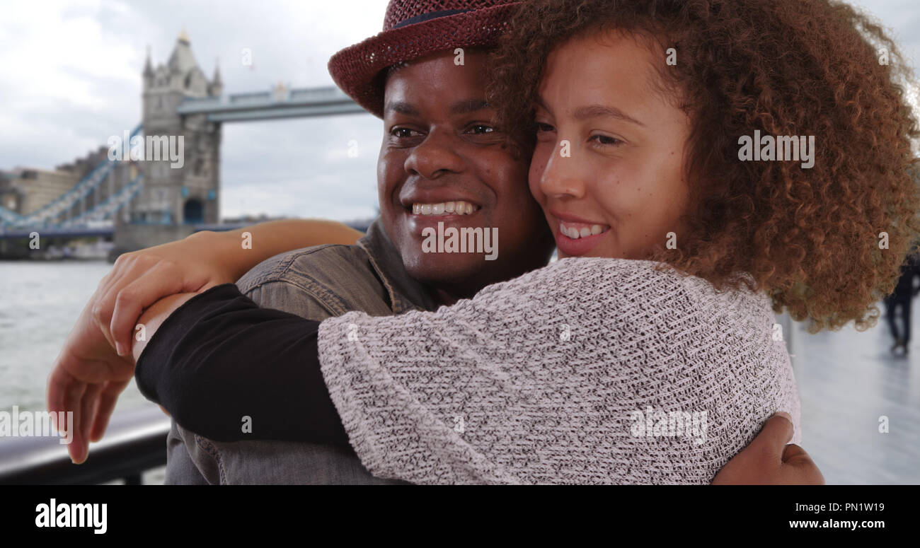 Glückliche junge afrikanische amerikanische Paar Lächeln und Umarmung von der Tower Bridge Stockfoto