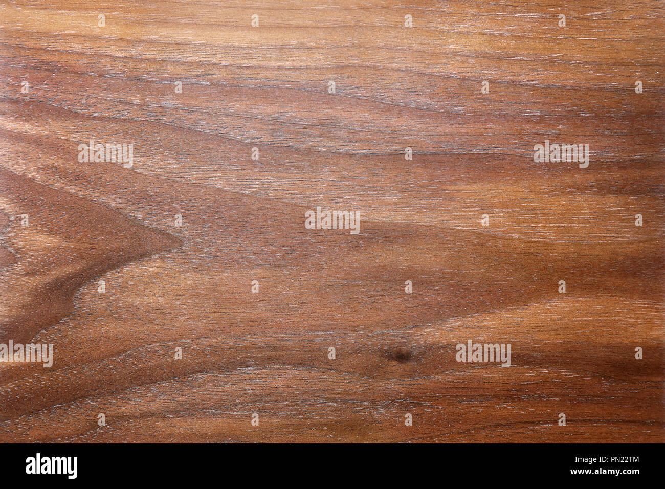 Ein Hintergrund der Reichen, braun gemustert und strukturierte Holzmaserung einer Planke aus Nussbaum. Stockfoto