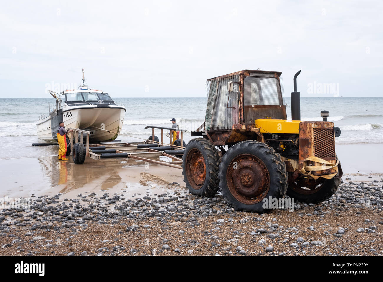 Fischer an Land in ihrem Boot auf den Strand bei Cromer, Norfolk, Großbritannien Stockfoto