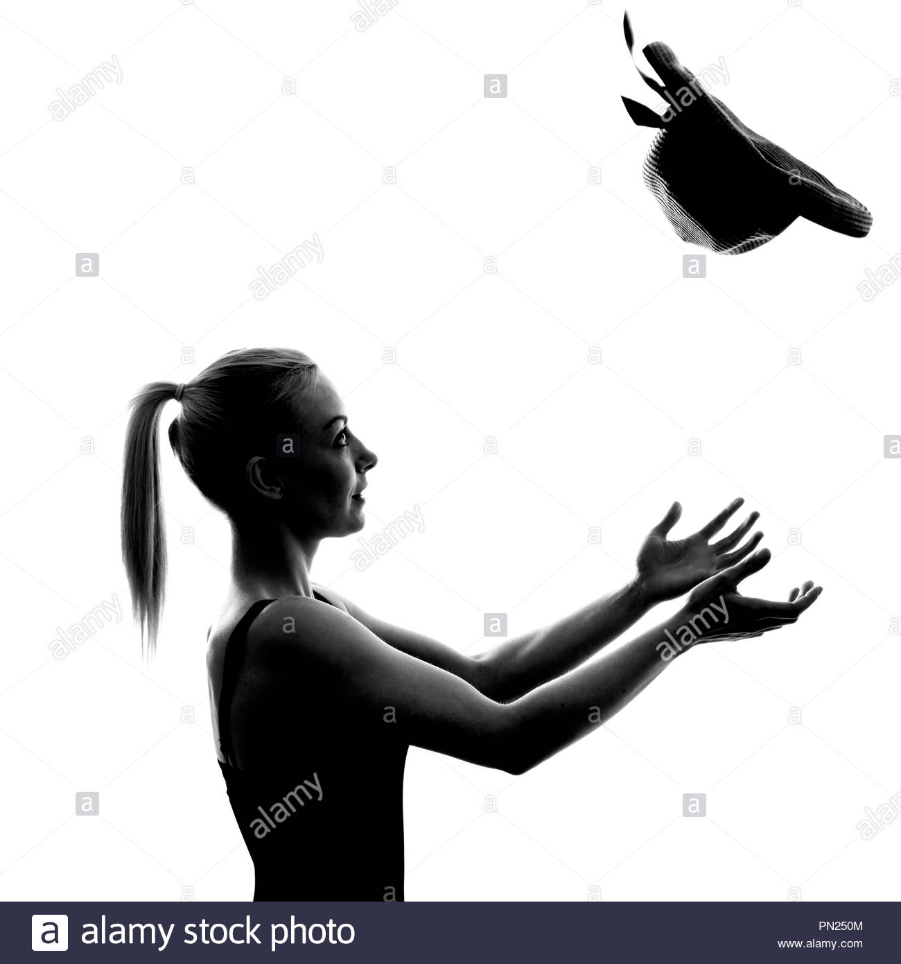 Frau mit Pferdeschwanz Fang einen Strohhut Stockfoto