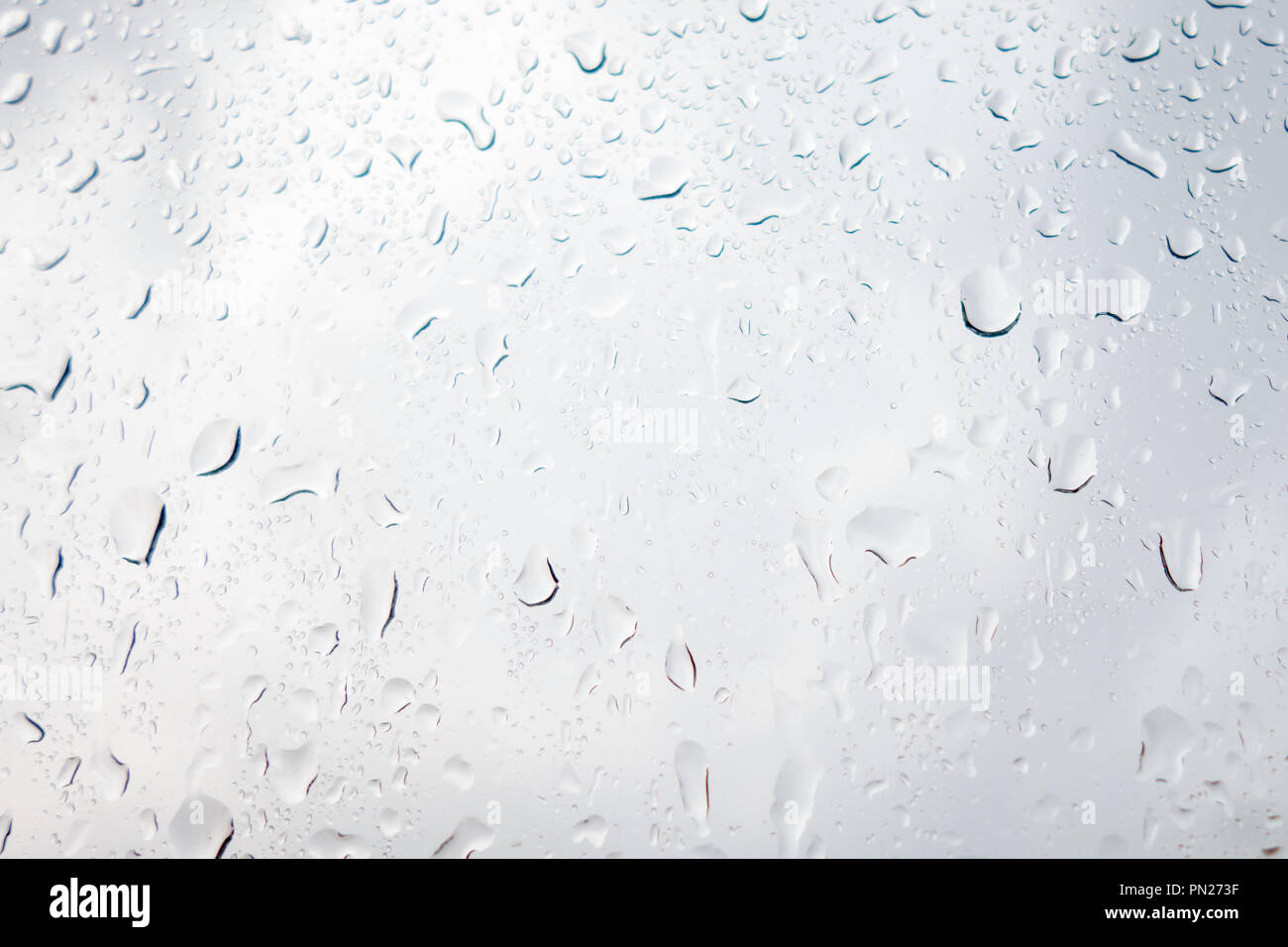 Regen fällt auf das Glas gegen einen stürmischen Himmel Stockfoto