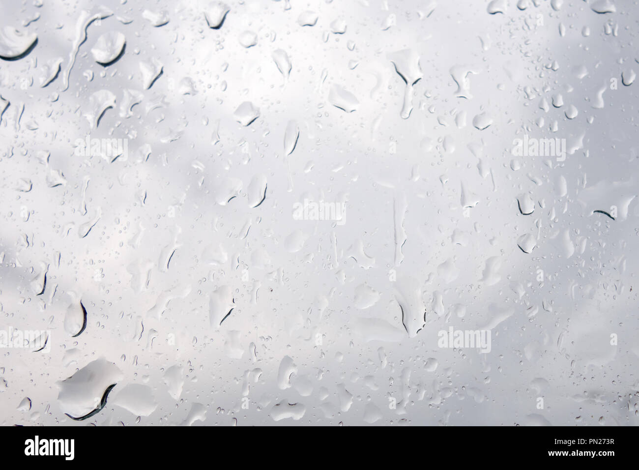 Regen fällt auf das Glas gegen einen stürmischen Himmel Stockfoto