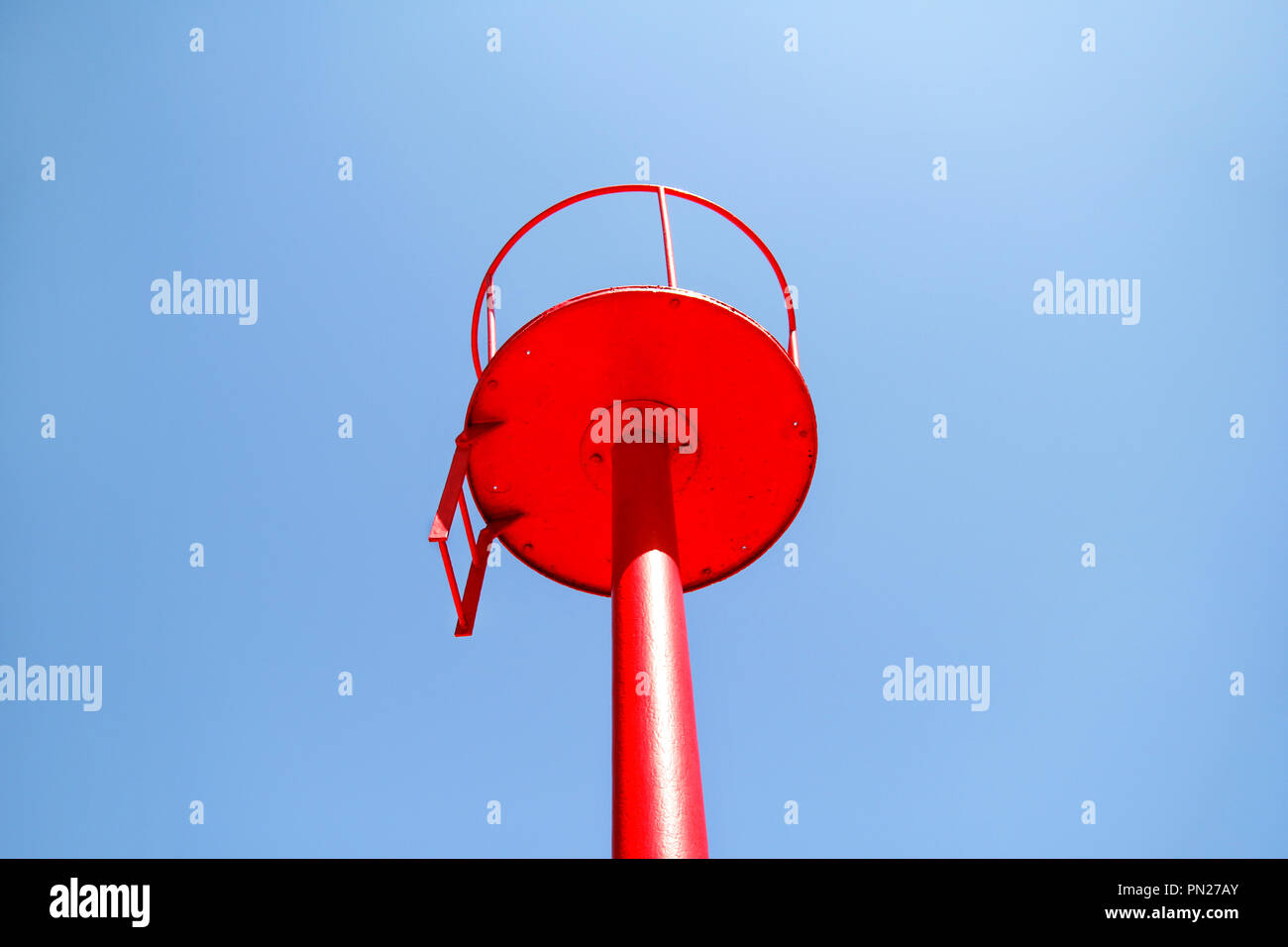 Rote Leuchtturm mit blauem Himmel Hintergrund isoliert. Stockfoto