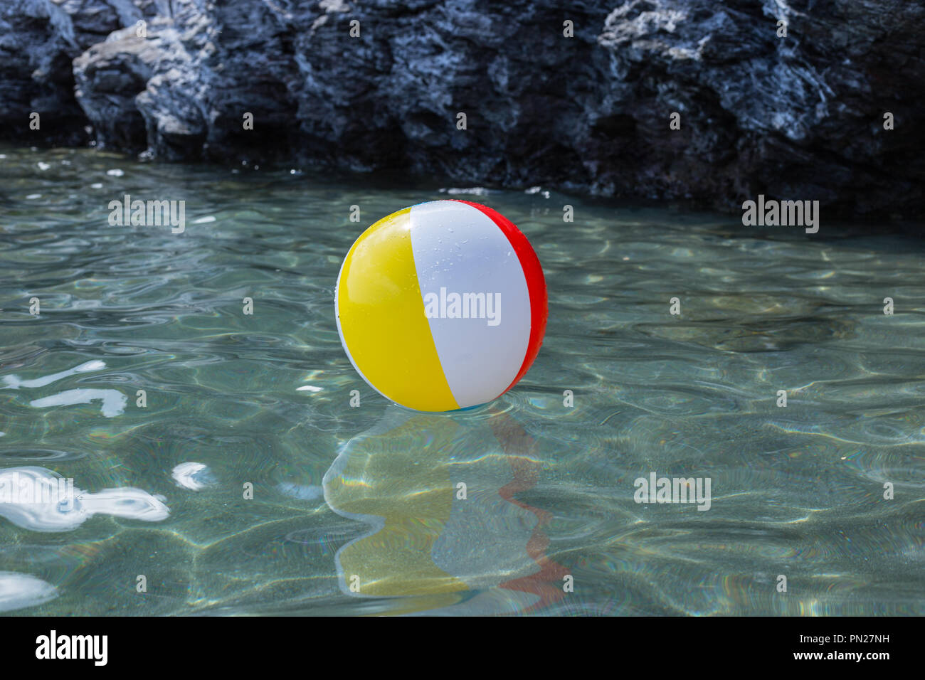 Große bunte Bälle auf dem Wasser im Meer am Strand Stockfoto