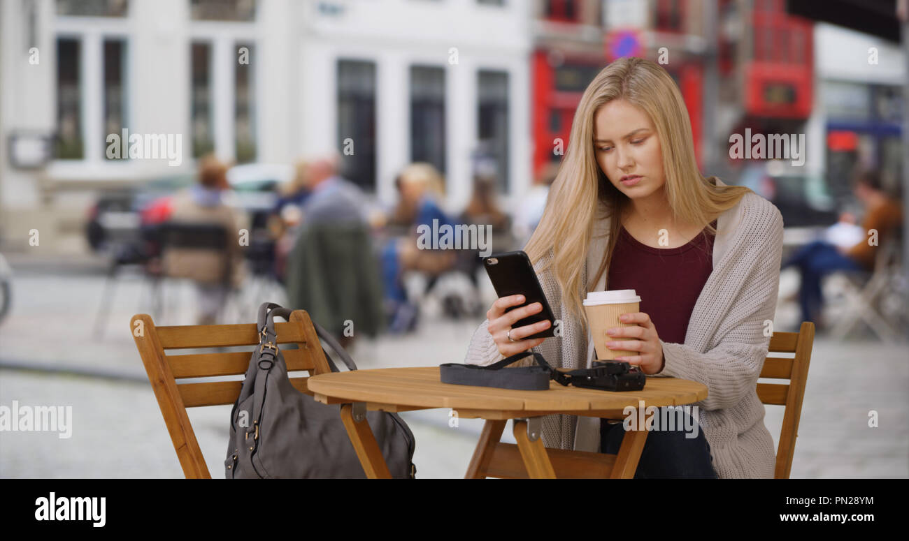 Junge weibliche Kaukasischen Tourist in Brügge Texte beim Trinken von Kaffee Stockfoto