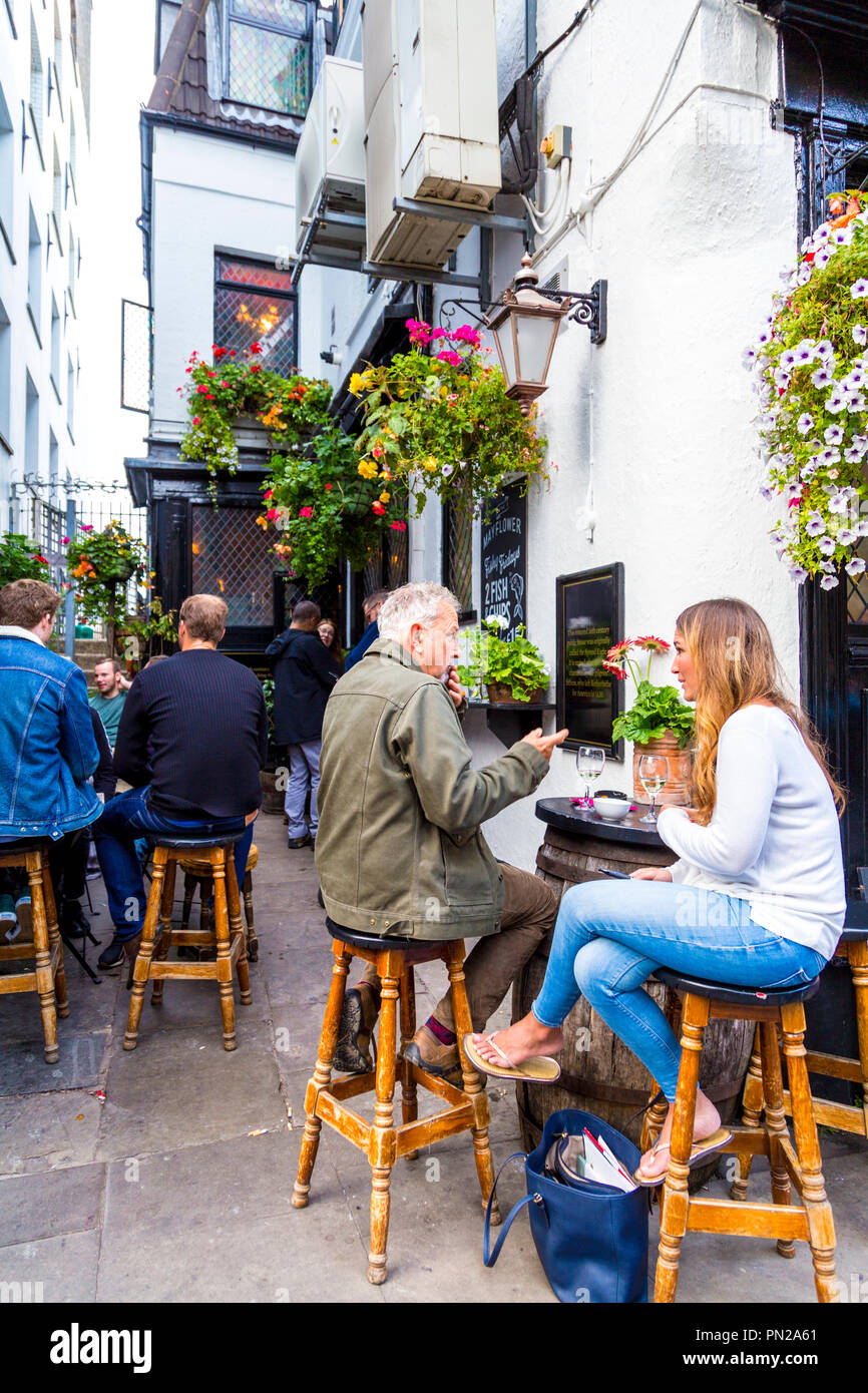 Menschen sitzen vor einem Pub auf Barhockern (die Mayflower, Rotherhithe, London, UK) Stockfoto