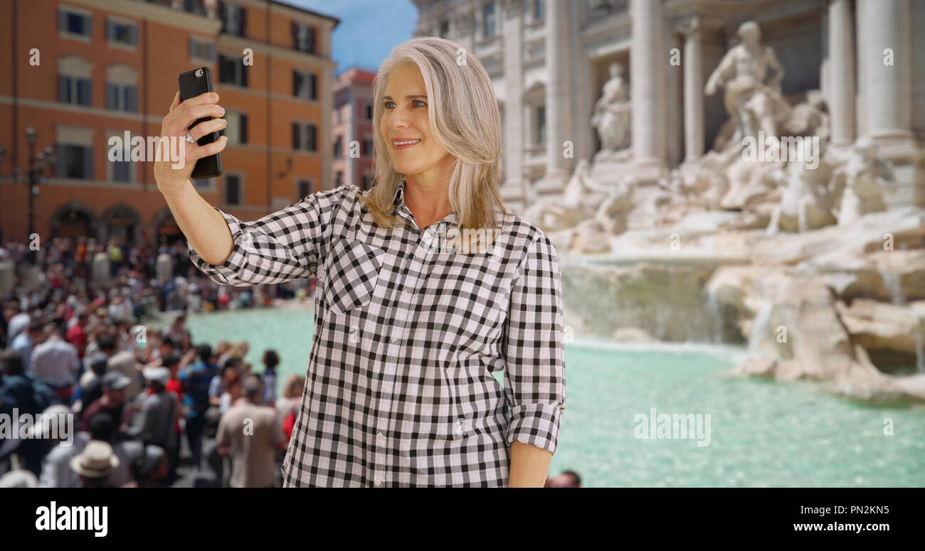 Ältere Frau nimmt eine selfie am Trevi-Brunnen in Rom Stockfoto