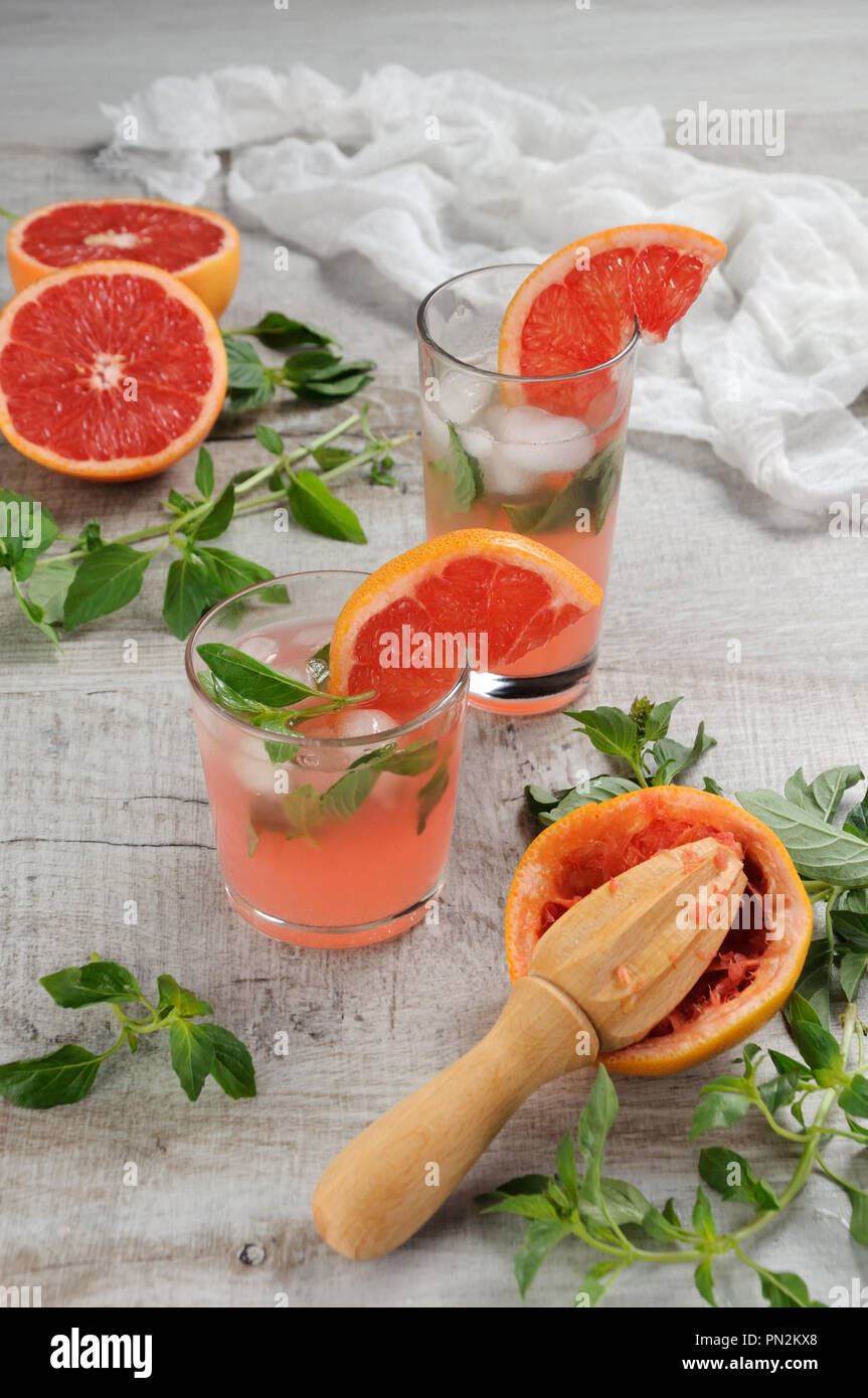 Cocktail Saft, gepressten roten Grapefruit und Blätter des zarten Basilikum Zitrone. Was könnte in einem FLIEGBAR, heissen, sonnigen Tag besser sein? Stockfoto