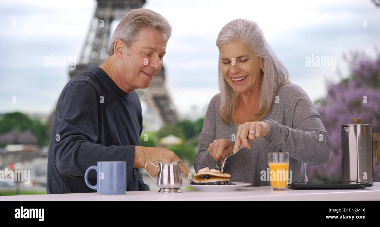 Ältere weiße männliche und weibliche in der Nähe von Eiffelturm Essen leckeres Frühstück Gebäck Stockfoto