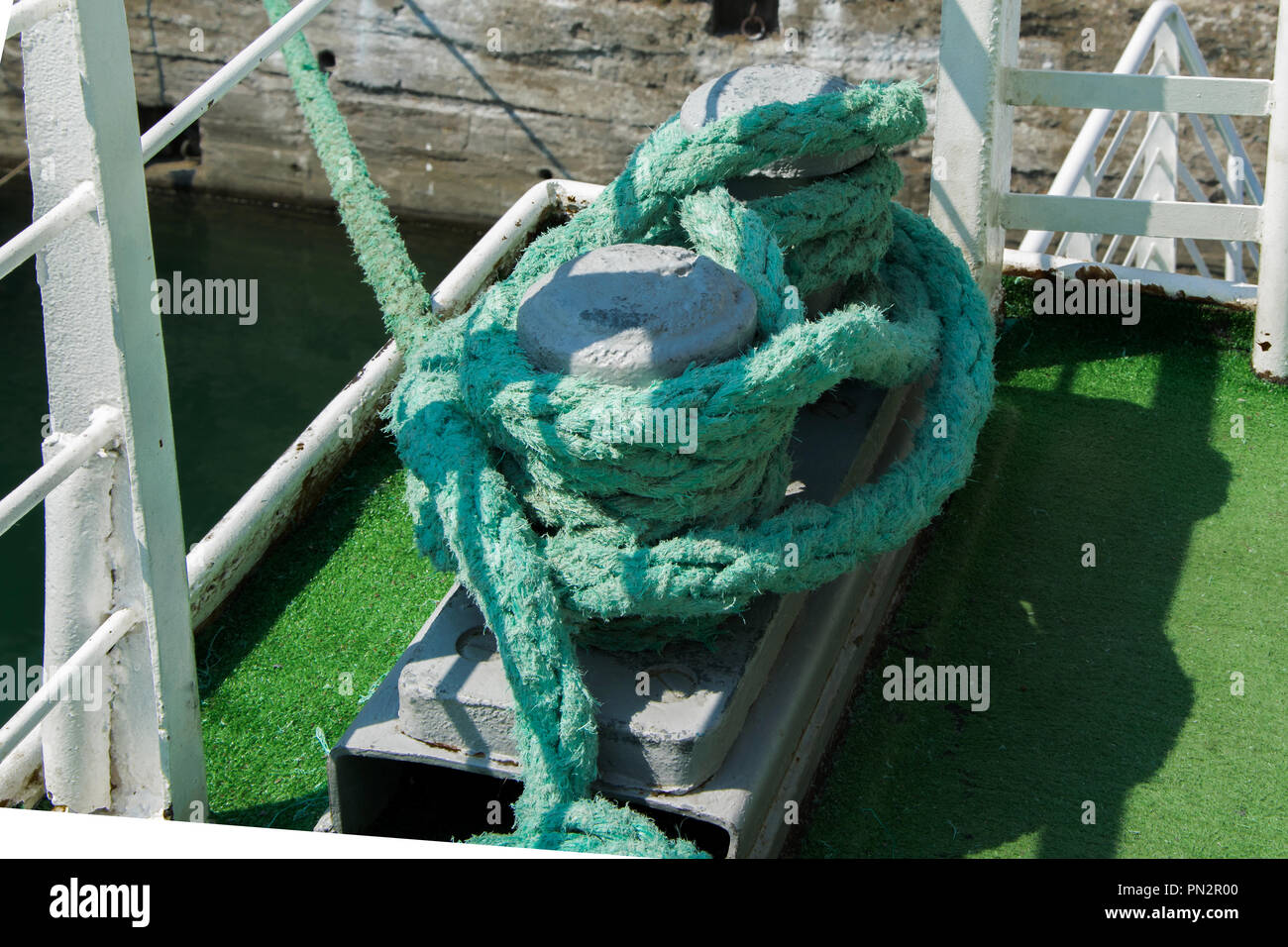 Metall rostet Poller mit schwerem, grünen Seile auf einem Schiff Stockfoto