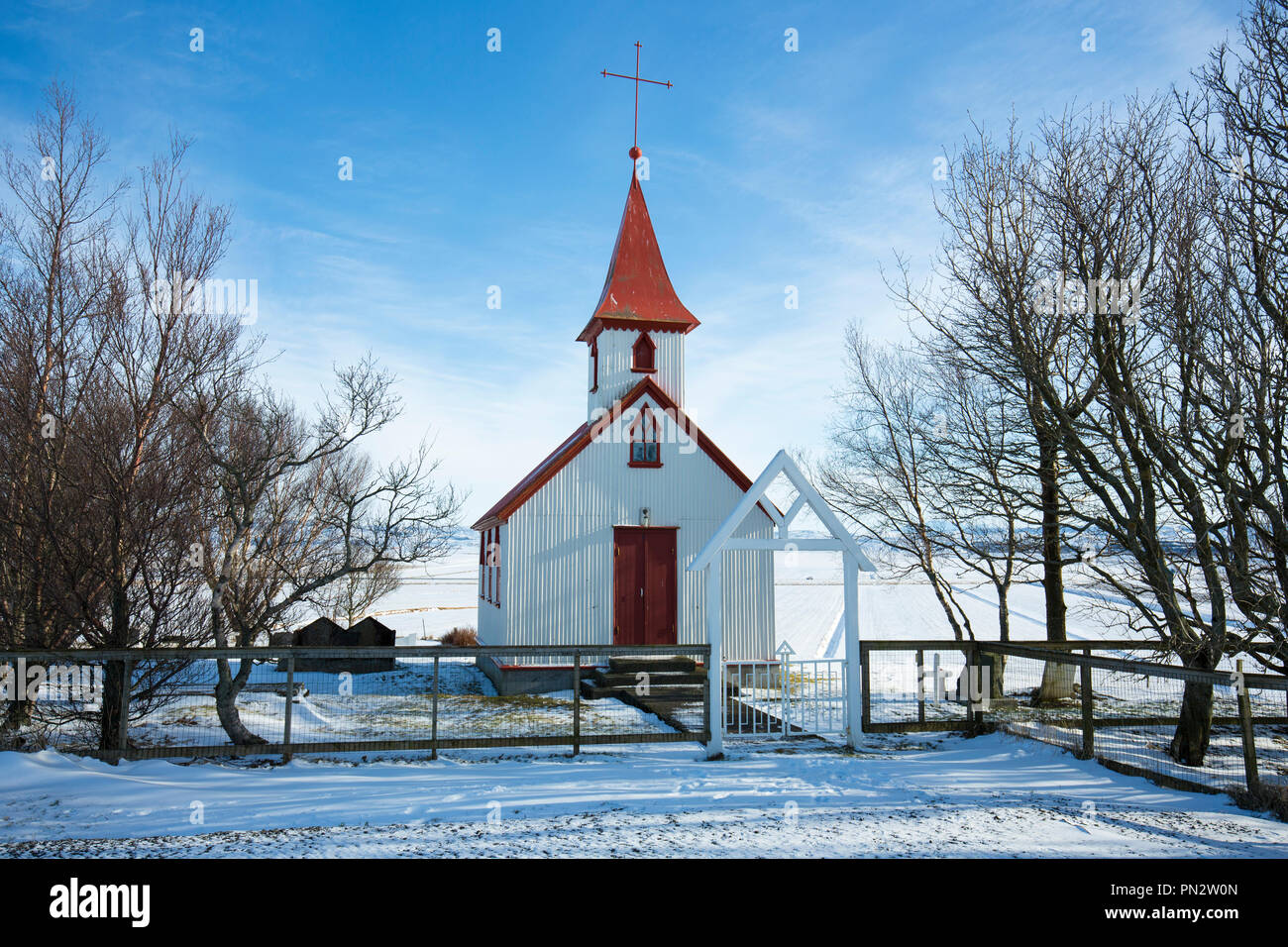 Urig typische traditionelle Kirche Braedratungukirkja mit roten Dach in verschneiter Landschaft in Island Stockfoto