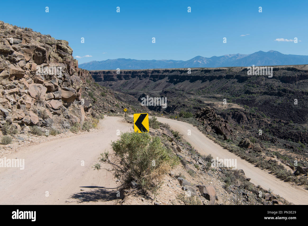 Direktionale Verkehrszeichen an einer Spitzkehre auf eine gefährliche Straße am Rande der Schlucht des Rio Grande Schlucht in der Nähe von Taos, New Mexico Stockfoto