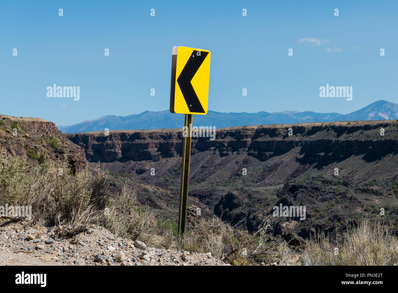 Linker Pfeil Schild an einer Spitzkehre auf einer Straße am Canyon Rim über dem Rio Grande Schlucht in der Nähe von Taos, New Mexico Stockfoto