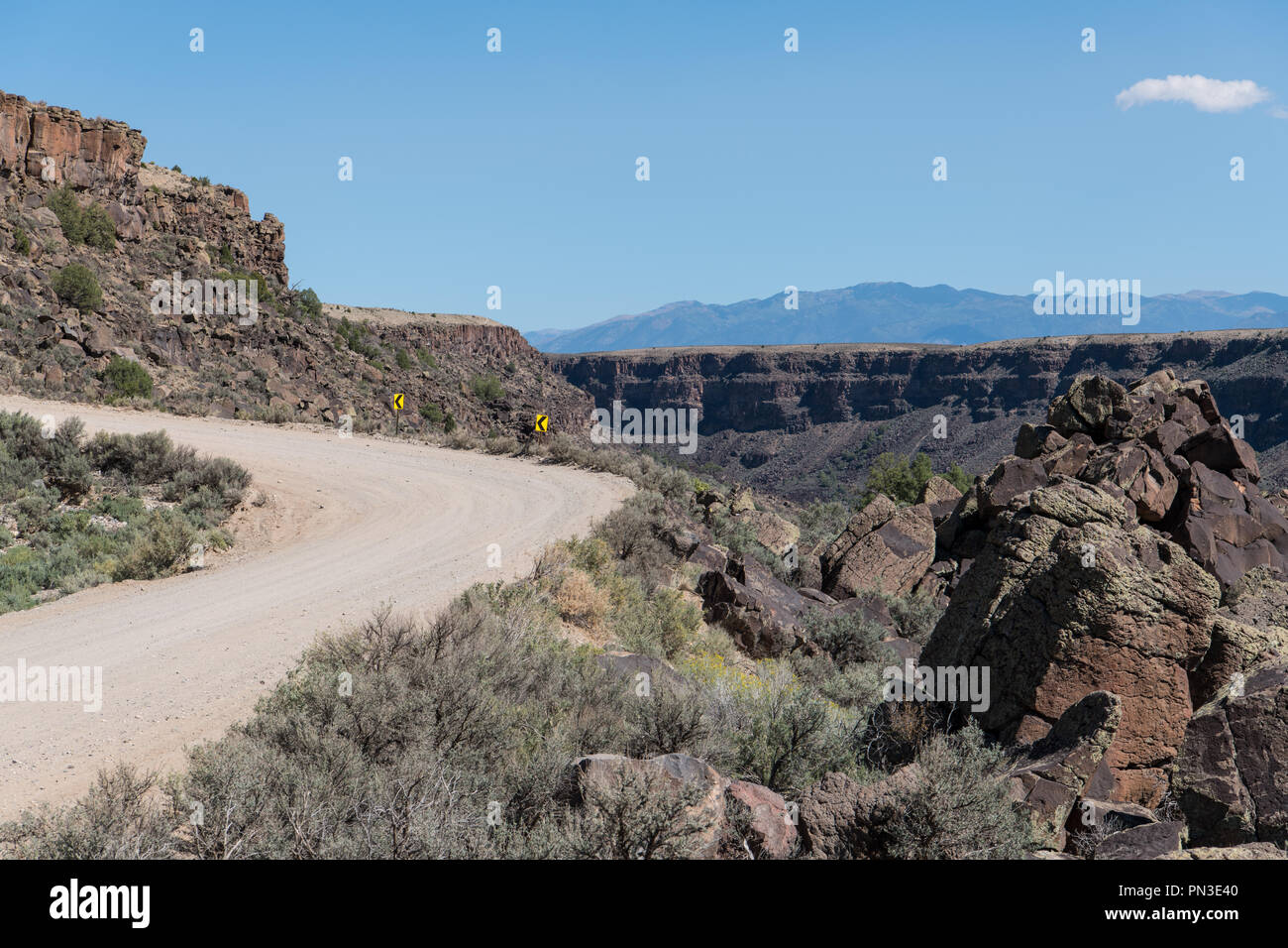 Dirt Road, geschwungene zu einem Canyon Rim mit Pfeil nach links Zeichen für ein gewundener - der Rio Grande Schlucht in der Nähe von Taos, New Mexico Stockfoto