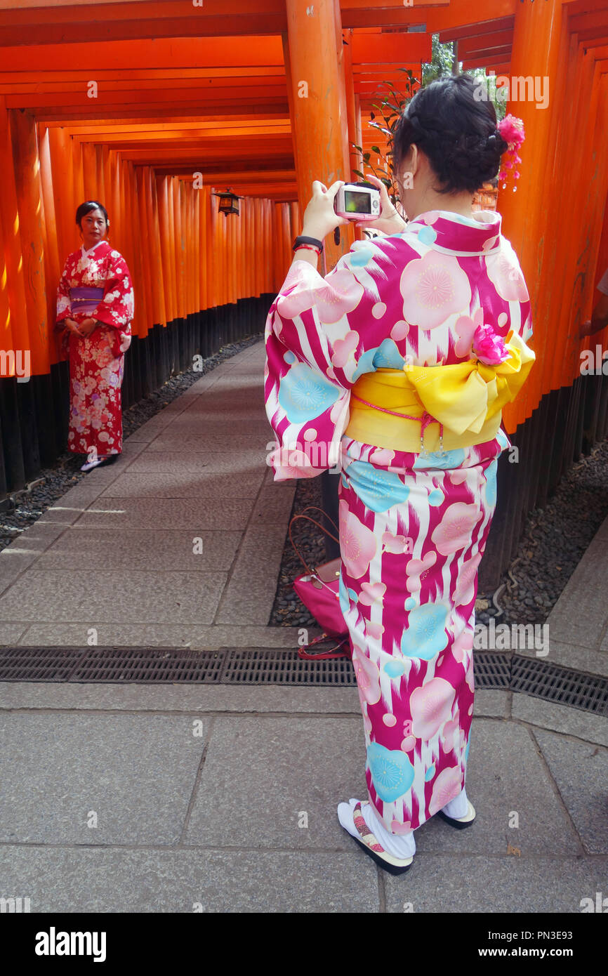 Junge Frauen in kimonos auf das Torii Tore, Fushimi Inari Schrein, Kyoto, Japan. Keine MR oder PR Stockfoto