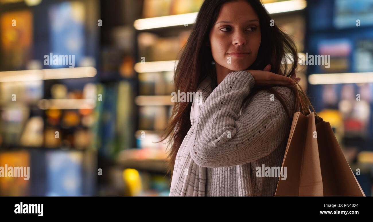 Seitenansicht des tausendjährigen Frau in Store Shop warten und lächelnd Stockfoto