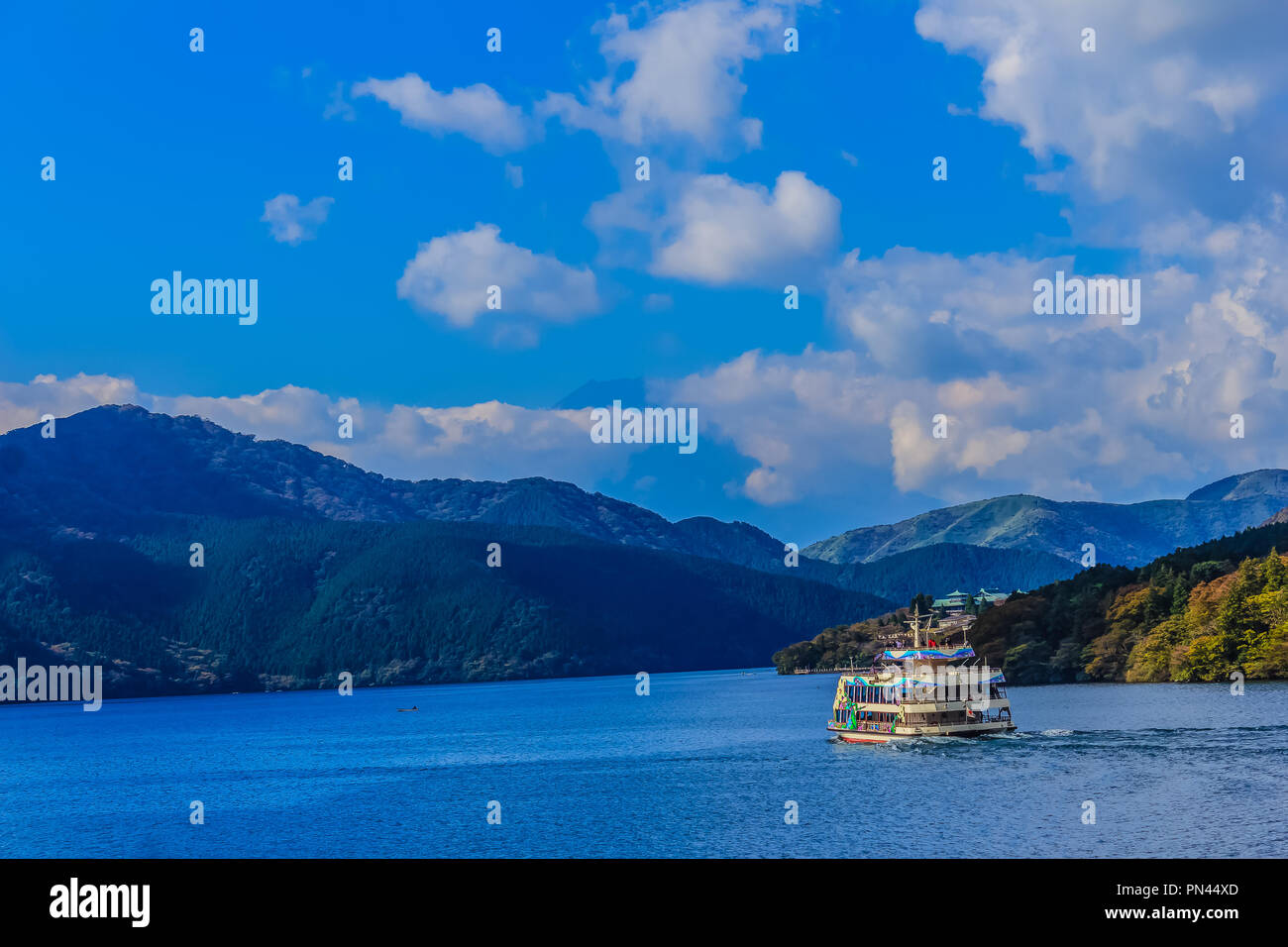 Touristische Kreuzfahrt auf dem Ashi-See mit Bergen und blauen Himmel im Hintergrund Stockfoto