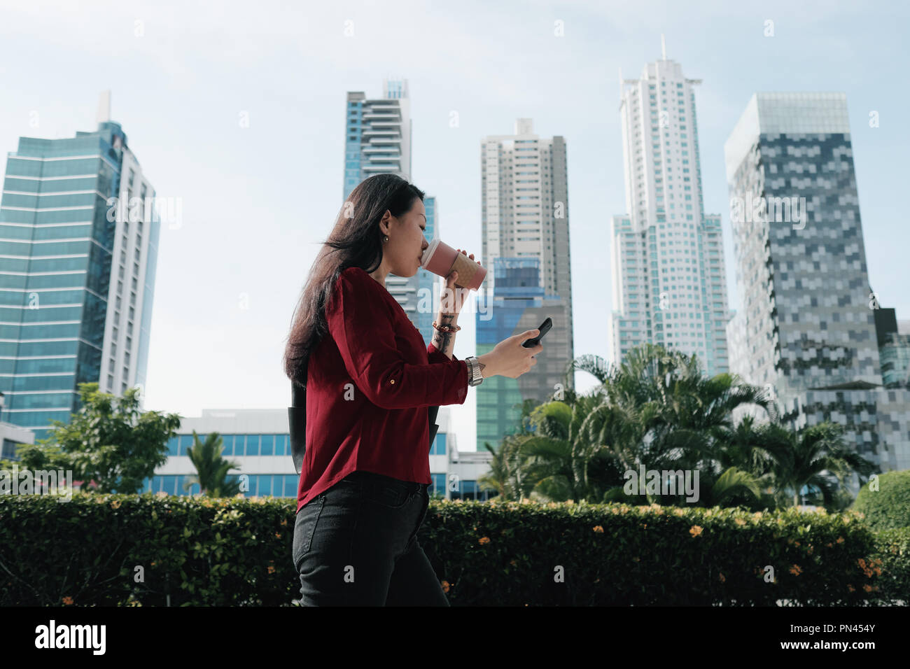 Chinesische Frau mit Telefon gehen und Kaffee trinken Stockfoto