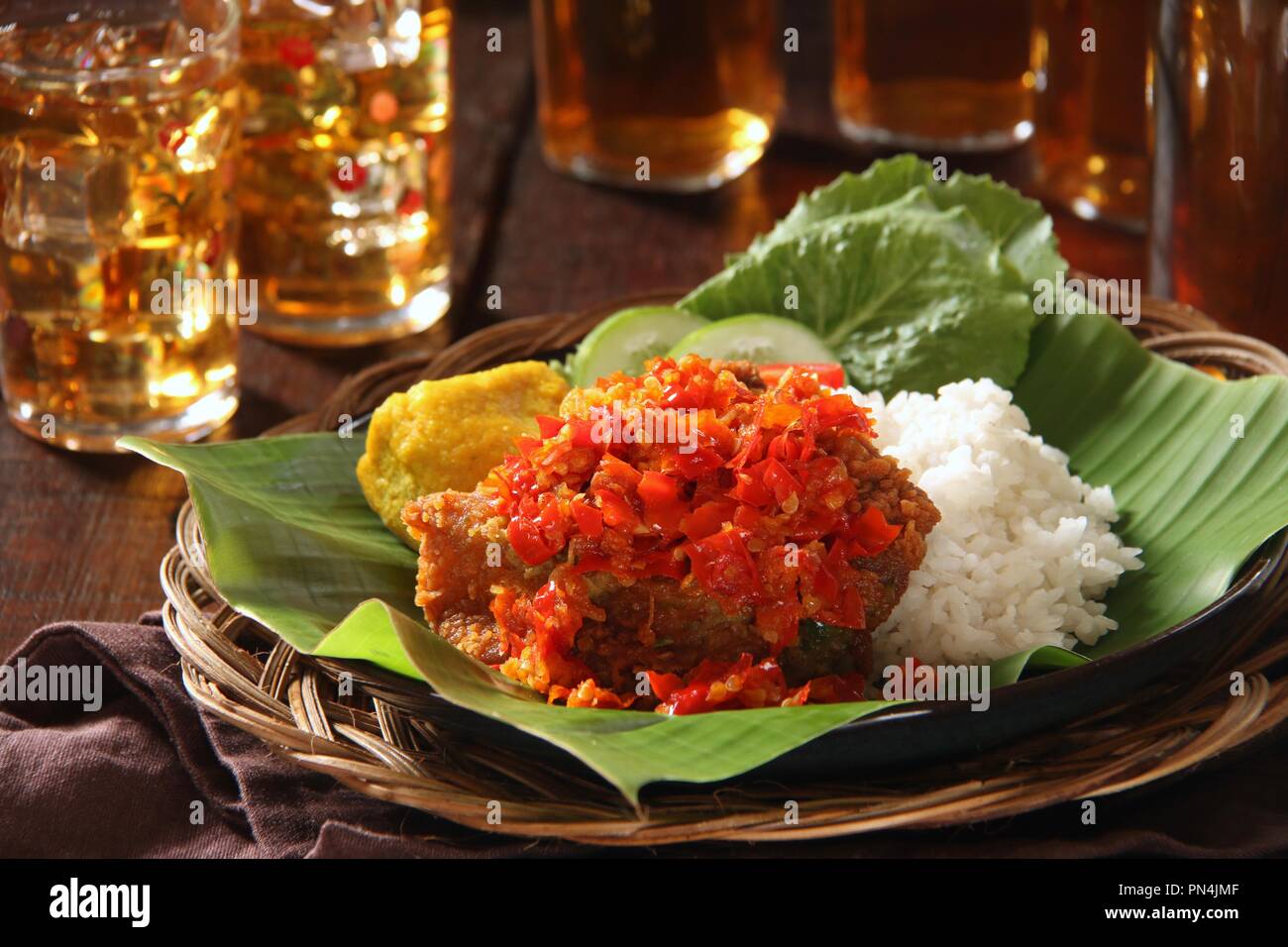 Ayam Geprek Balado. Fusion Street Food Gericht der Southern Fried Chicken gekrönt mit Sambal Lado oder Sambal Oelek, den traditionellen roten Chili paste. Stockfoto