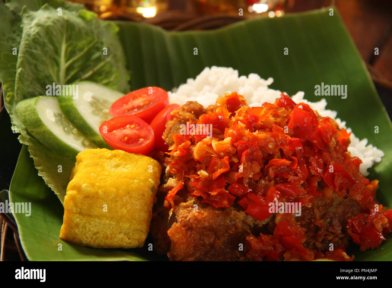 Ayam Geprek Balado. Fusion Street Food Gericht der Southern Fried Chicken gekrönt mit Sambal Lado oder Sambal Oelek, den traditionellen roten Chili paste. Stockfoto