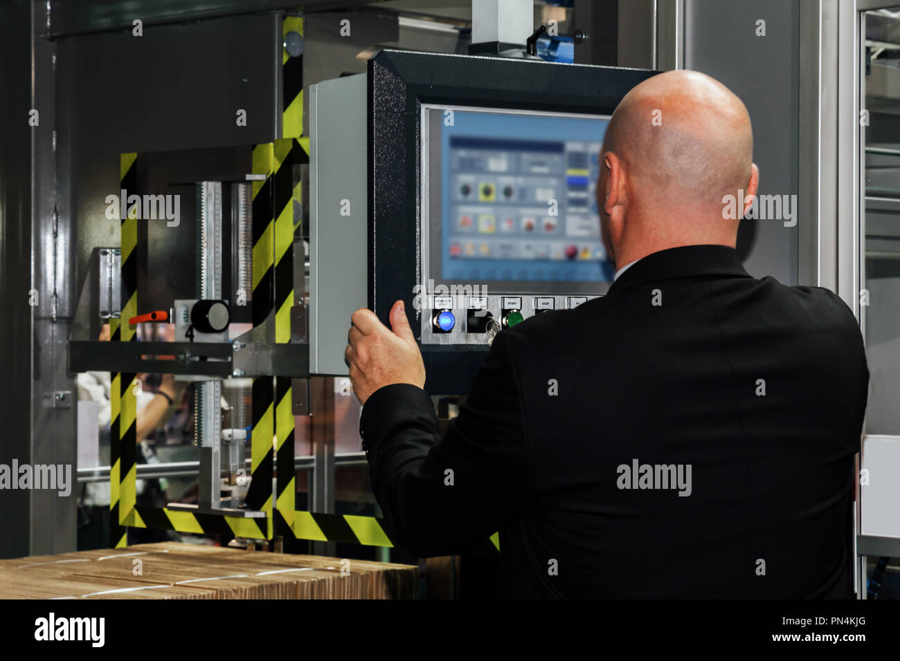 Factory Ingenieur Controlling und drücken wichtige Technologie-Taste am Bedienfeld einer automatischen Maschine in der Fertigung. Stockfoto