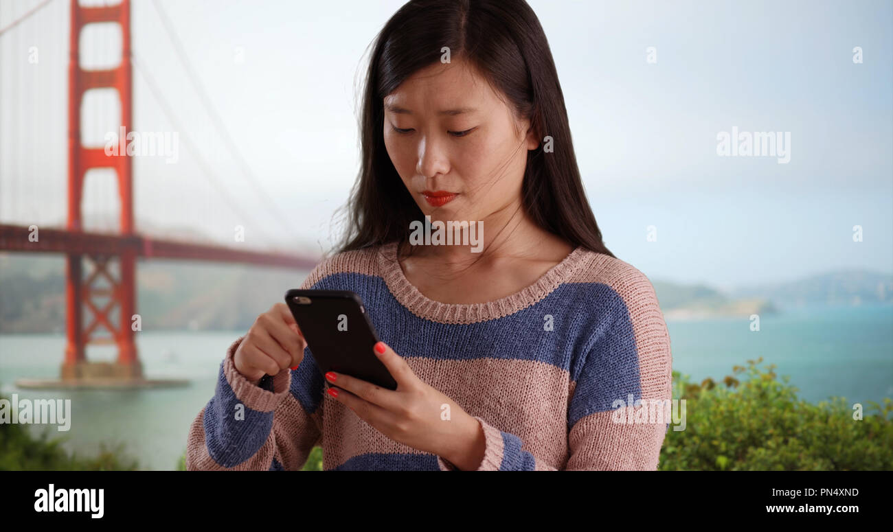 Nahaufnahme der netten Frau mit Handy und Senden von Texten in San Francisco Stockfoto