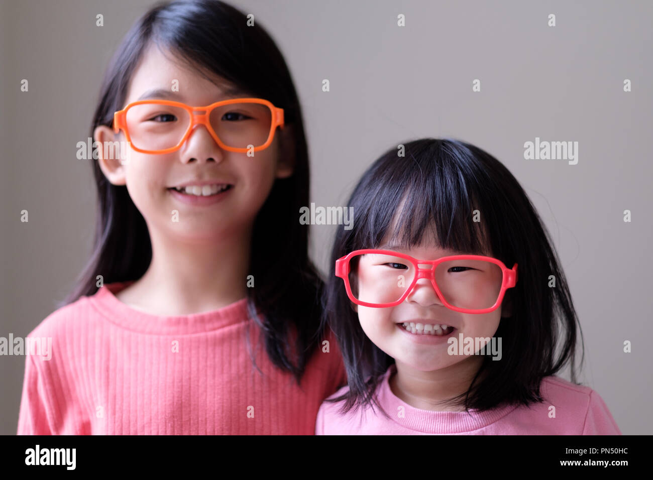 Zwei kleine Schwestern mit großen Brillen Stockfoto