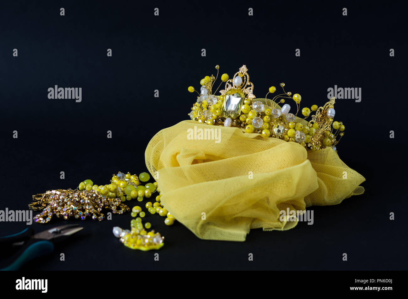 Eine Reihe von gelben Verzierungen. Gelbe Krone und Ohrringe. Master Class. Stockfoto