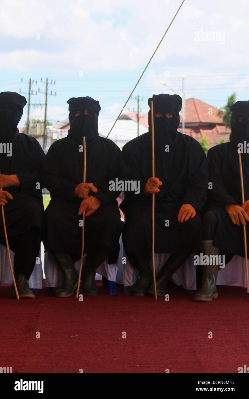 Meulaboh, Aceh, Indonesien. 20 Sep, 2018. Das Auspeitschen enforcers gesehen, bevor die Gefangenen. 19 Personen (18 Männer und 1 Frau), die von der Meulaboh Scharia-gericht von im öffentlichen gepeitscht wird für Kinder sexuell mißbrauchen und Glücksspiel verurteilt wurden. Die Anwendung von Züchtigung (TREIBEND) in Aceh ist im Lichte der Öffentlichkeit erfolgt, in der Regel vor der Moschee durchgeführt die Folgen der eine abschreckende Wirkung auf die Täter, die islamische Scharia verstoßen anzuzeigen. Trotz Kritik von Seiten der internationalen Gemeinschaft, bis jetzt Aceh immer noch die islamische Scharia gilt. (Bild: © Mimi Sapu Stockfoto