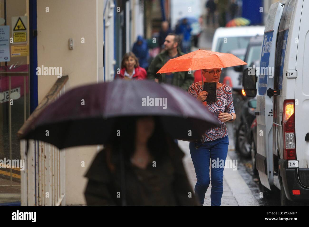 Menschen zu Fuß auf der Straße im Regen mit Sonnenschirmen. Großbritannien Stockfoto