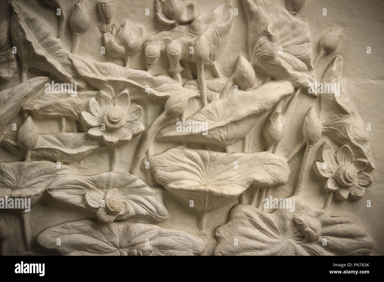 Schönen weißen Lotus Stuck auf der Mauer gemustert. Vintage White Wand  relief Stuck in Putz, stellt Lotus Blumen Hintergrund Stockfotografie -  Alamy