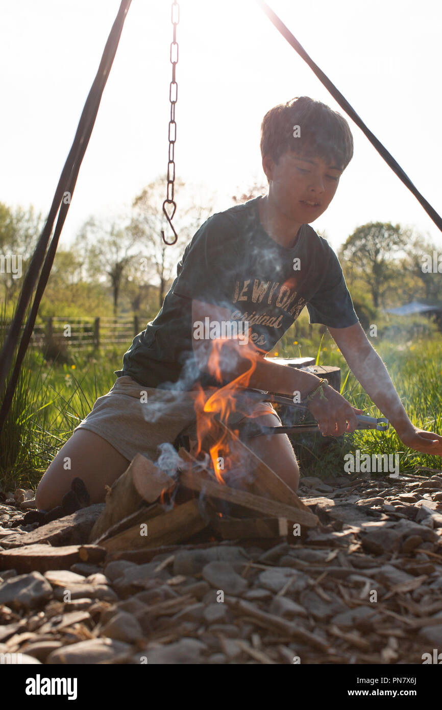 Ein Junge Beleuchtung ein Lagerfeuer. Stockfoto