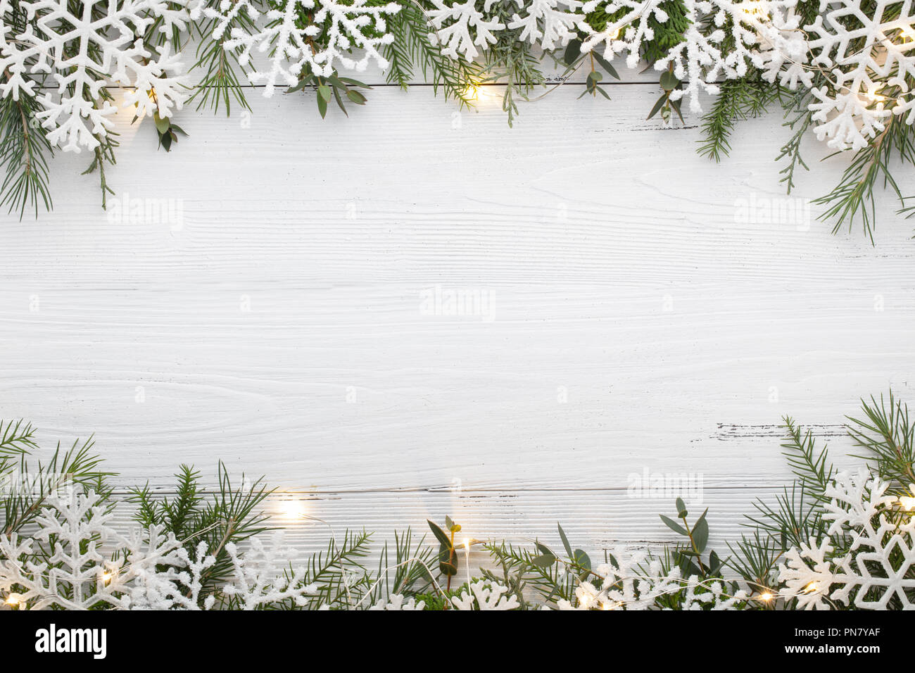 Schneeflocke und Weihnachtslichter auf hölzernen Tisch Stockfoto