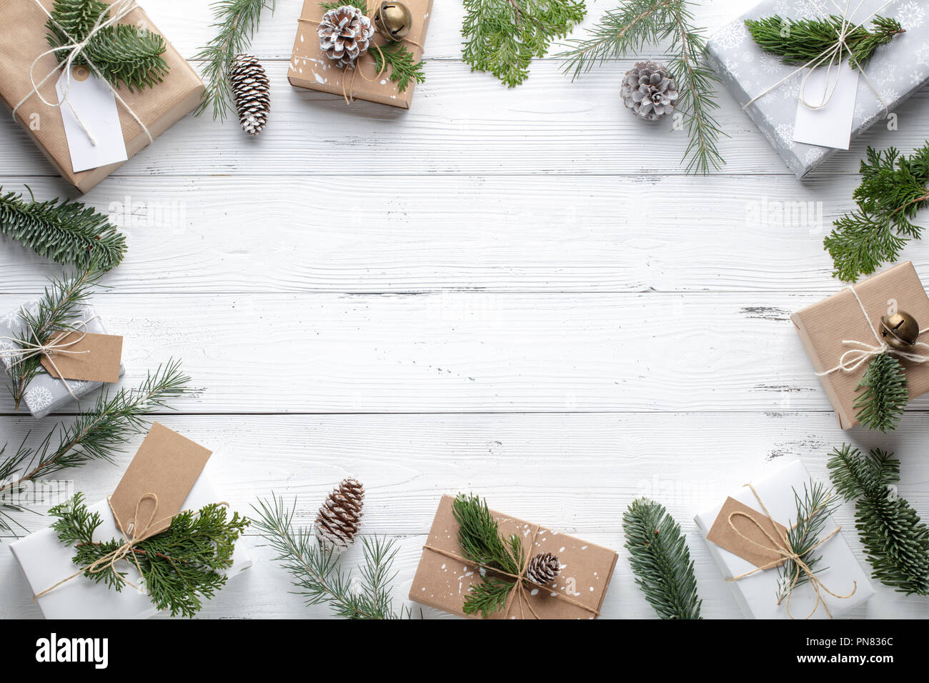 Weihnachten Geschenk, gestrickte Decke und Tannenzweigen auf hölzernen weißen Hintergrund. Flach, Ansicht von oben. Stockfoto