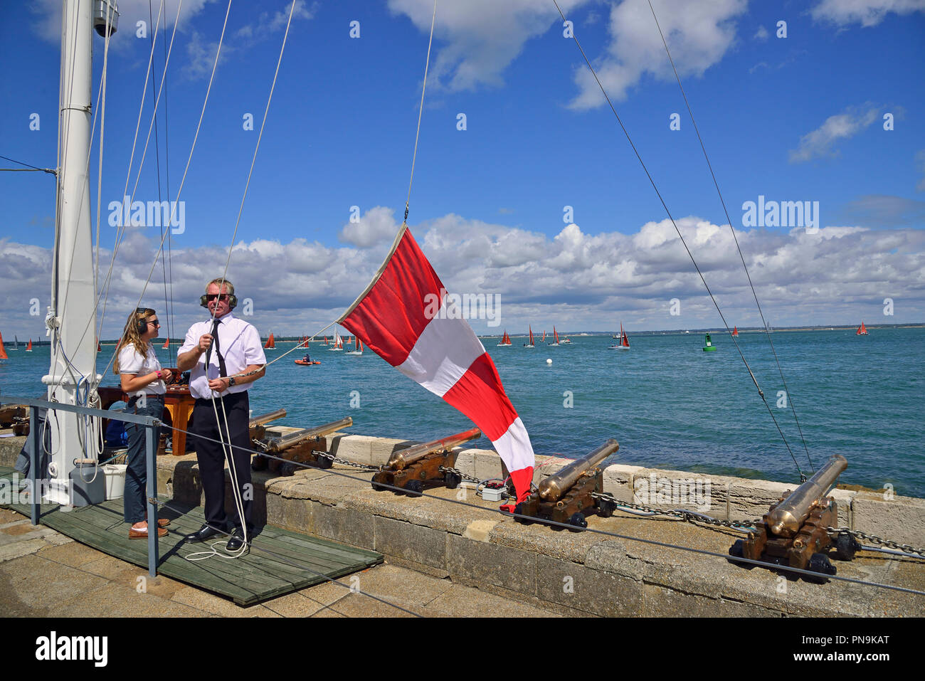 Beamte, die die Startlinie des Royal Yacht Squadron, Cowes, heben die Verschiebung Flagge, die zeigt an, dass ein Rennen nicht gestartet wird verschoben, IOW, Großbritannien Stockfoto