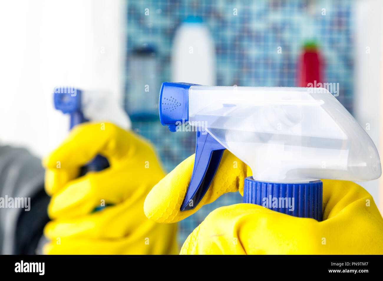 Person, Aufgaben im Bad zu Hause Spiegel mit Spray Reinigungsmittel reinigen Stockfoto