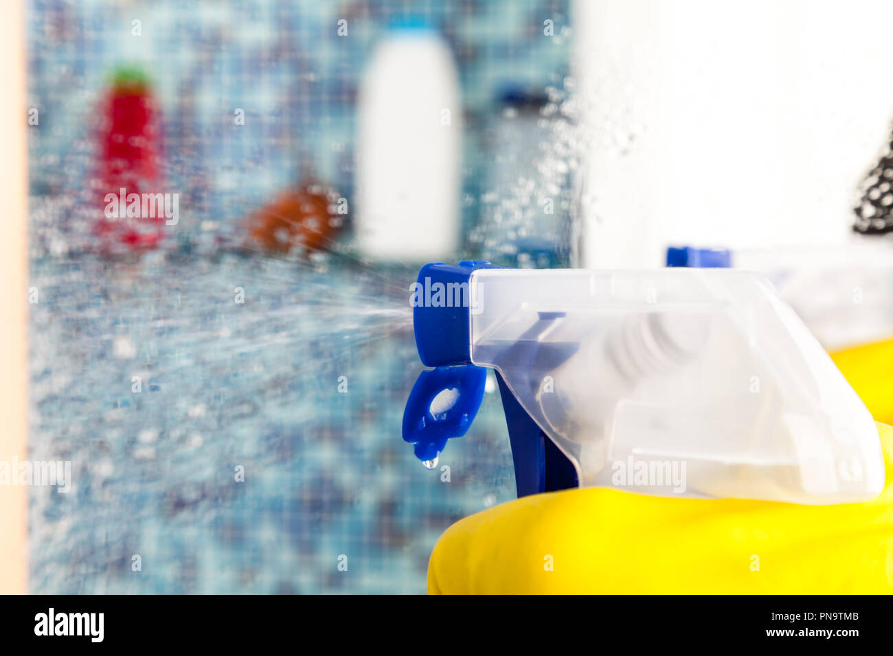 Person, Aufgaben im Bad zu Hause Spiegel mit Spray Reinigungsmittel reinigen Stockfoto