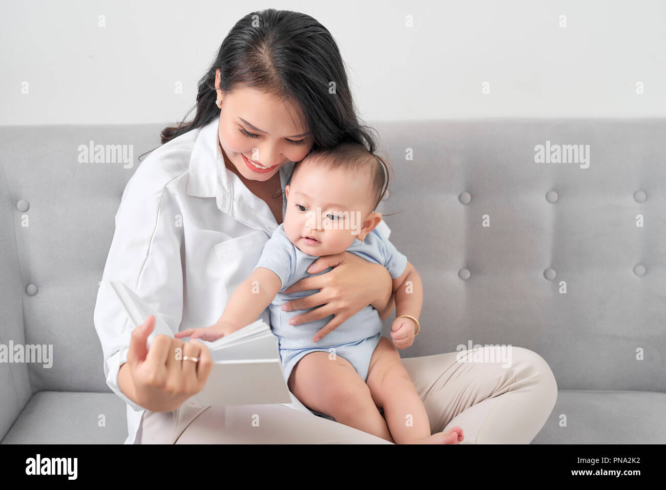 Jungen asiatischen Mutter Lesung Buch zum Baby. Süßer Moment. Stockfoto