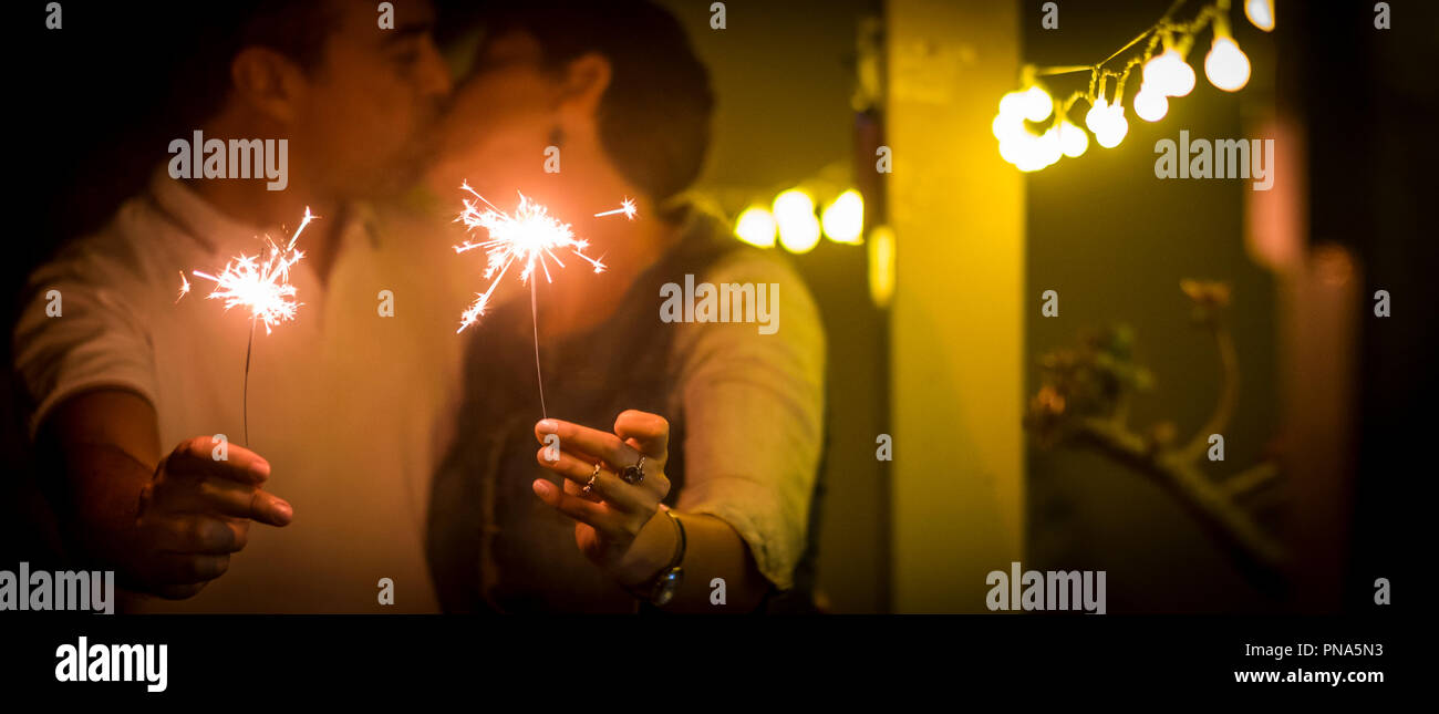 Romantisches Paar der kaukasischen Mann und Frau küssen und lieben während einer Party Feier. Nehmen und funkelnde Feuer auf die Hände benutzen. Silvester perfekte p Stockfoto
