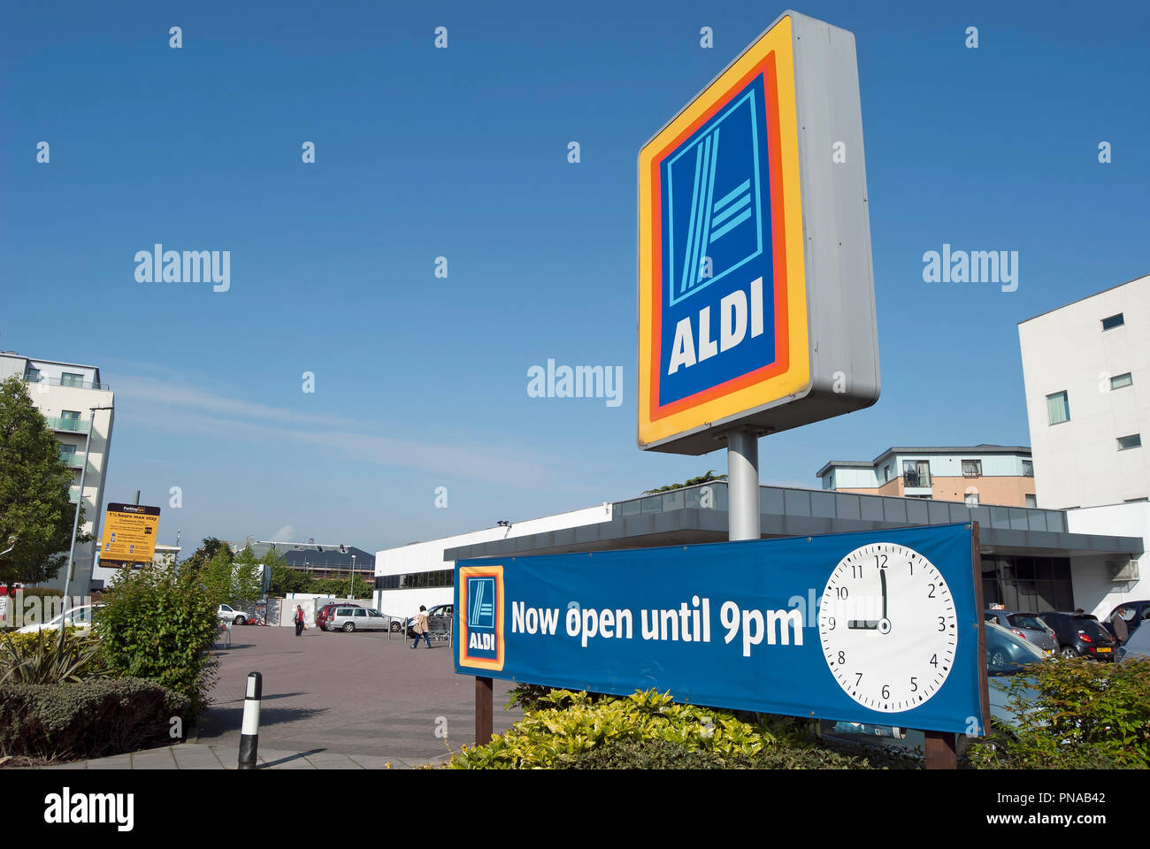 Schild mit Name und Logo von Aldi, bei einer Filiale der Supermarktkette in  Hounslow, Middlesex, England, mit weiteren Seufzer, jetzt bis 21 Uhr  geöffnet Stockfotografie - Alamy