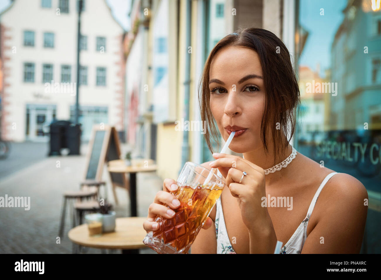 Junge brünette Frau mit Eis Tee im Café. Stockfoto