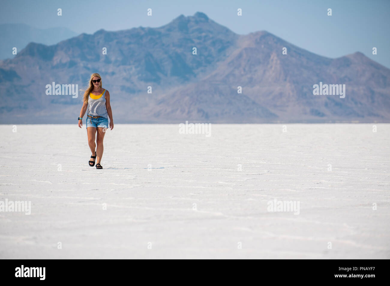 Eine blonde Frau geht über Bonneville Salt Flats, Tooele County, Utah, USA. Stockfoto