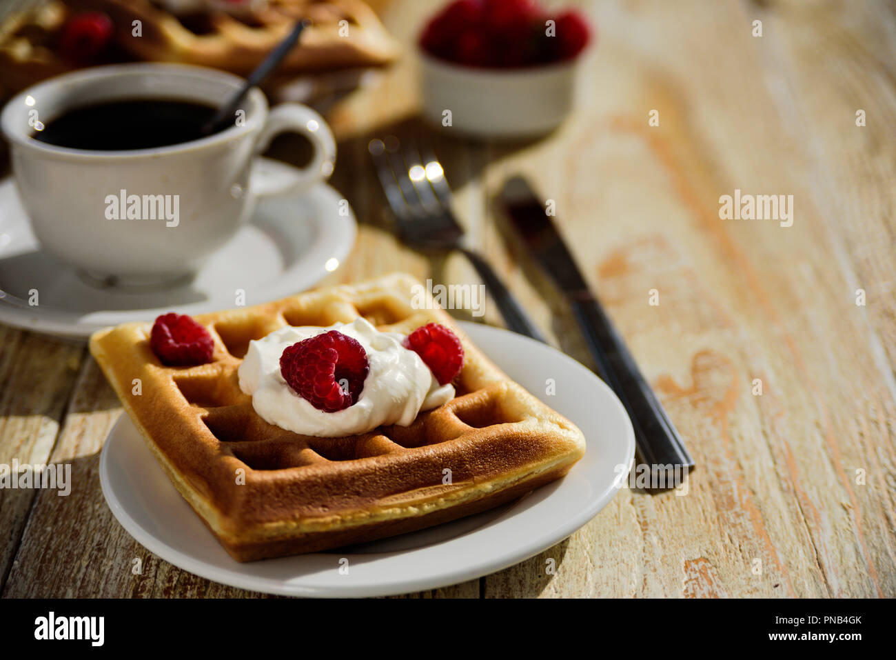 Belgische Waffeln mit Himbeeren und Sahne zum Frühstück Stockfoto