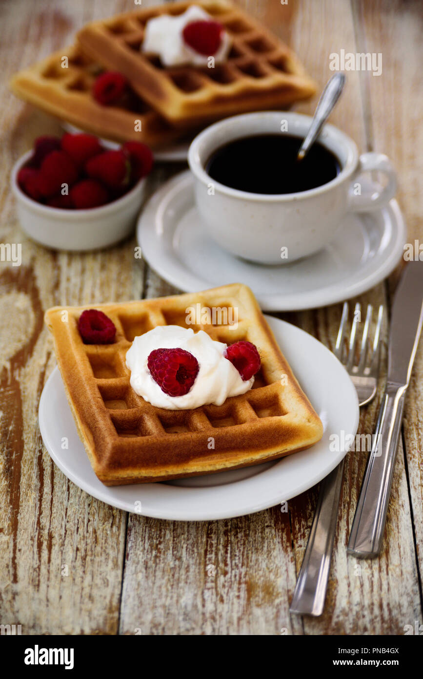 Belgische Waffeln mit Himbeeren und Sahne zum Frühstück Stockfoto