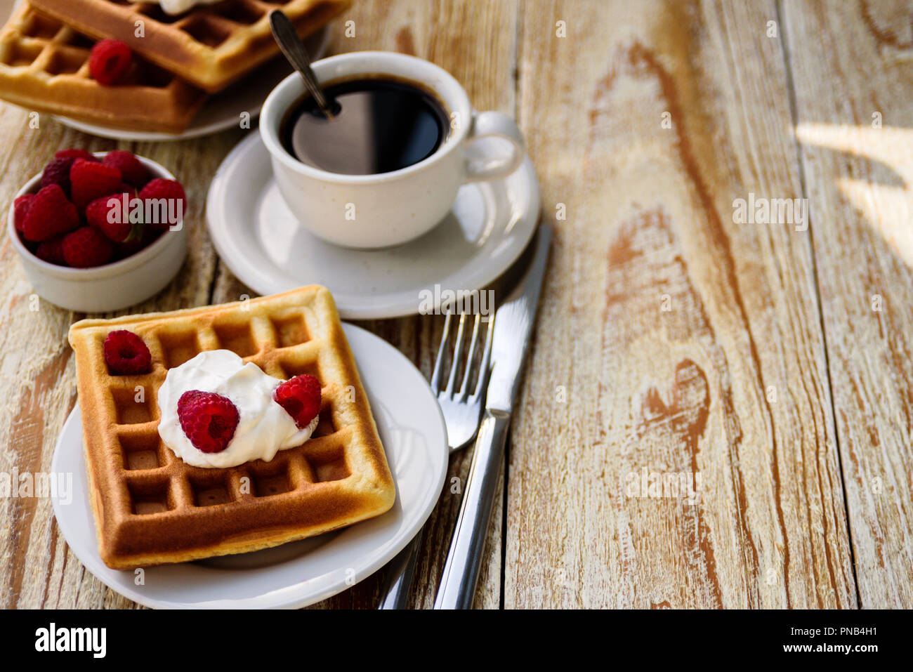 Belgische Waffeln mit Himbeeren und Sahne zum Frühstück Stockfoto
