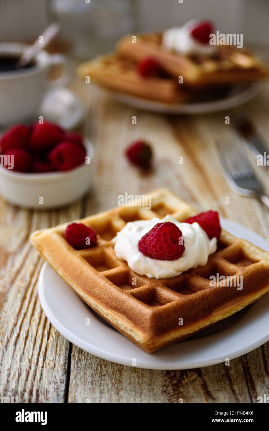 Belgische Waffeln mit Himbeeren und Sahne zum Frühstück Stockfoto
