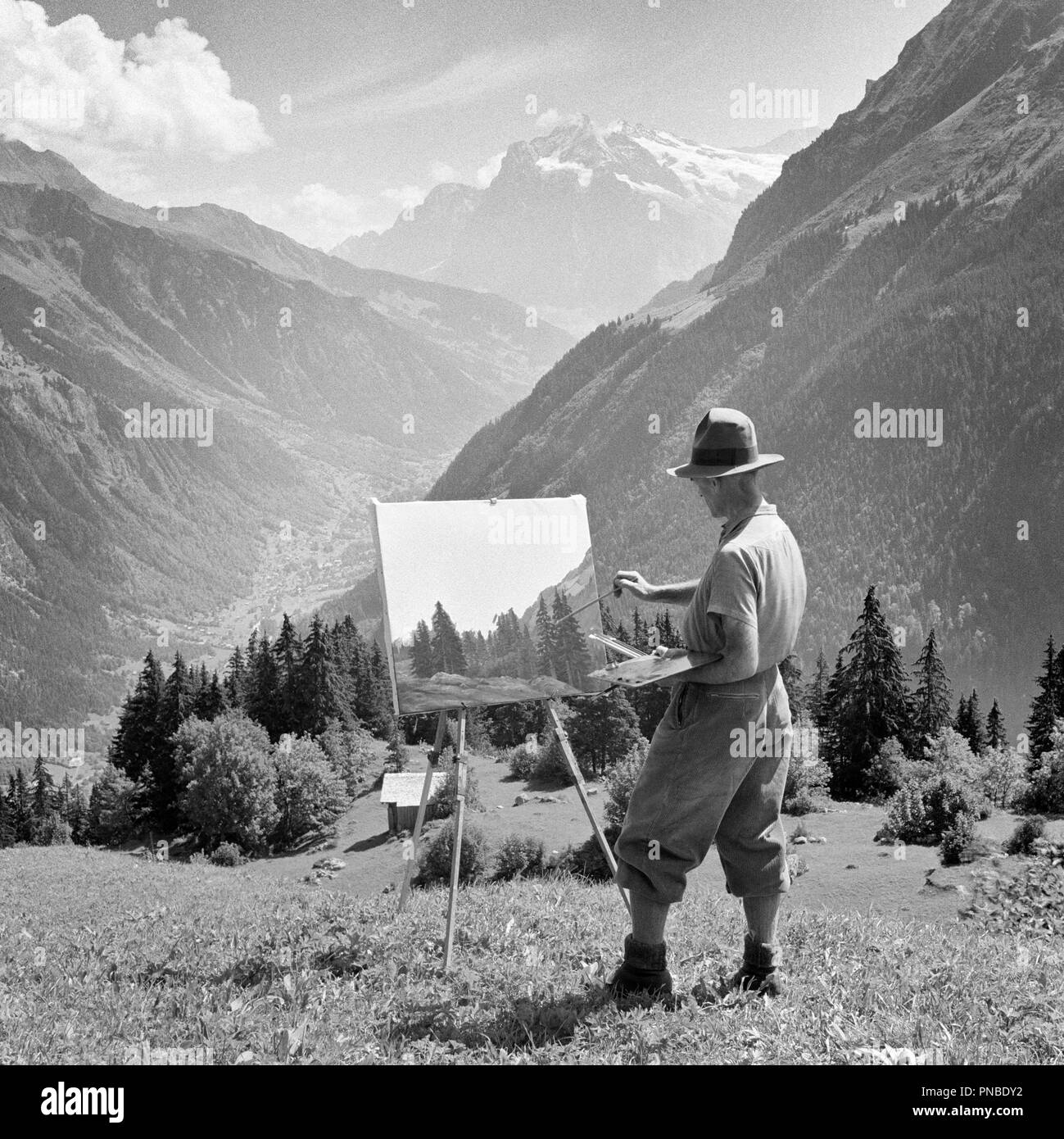 1920er Jahre 1930er Jahre Künstler ARBEITEN AN MALEREI STEHEND AN STAFFELEI  im Berner Oberland SCHWEIZ - 1945