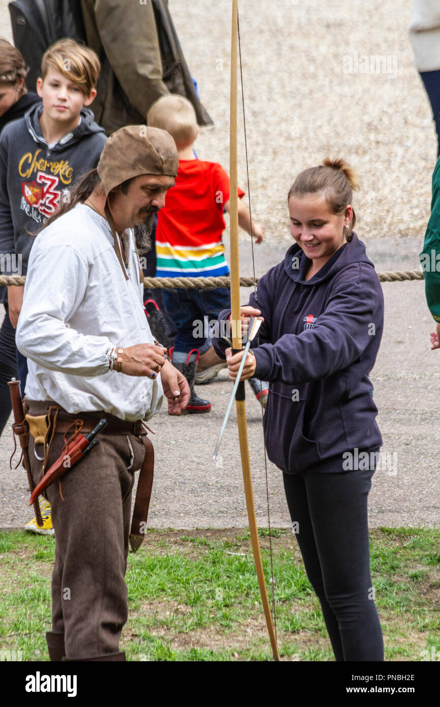 Junge Frau testen einen Langbogen zu einem Ritterturnier Stockfoto